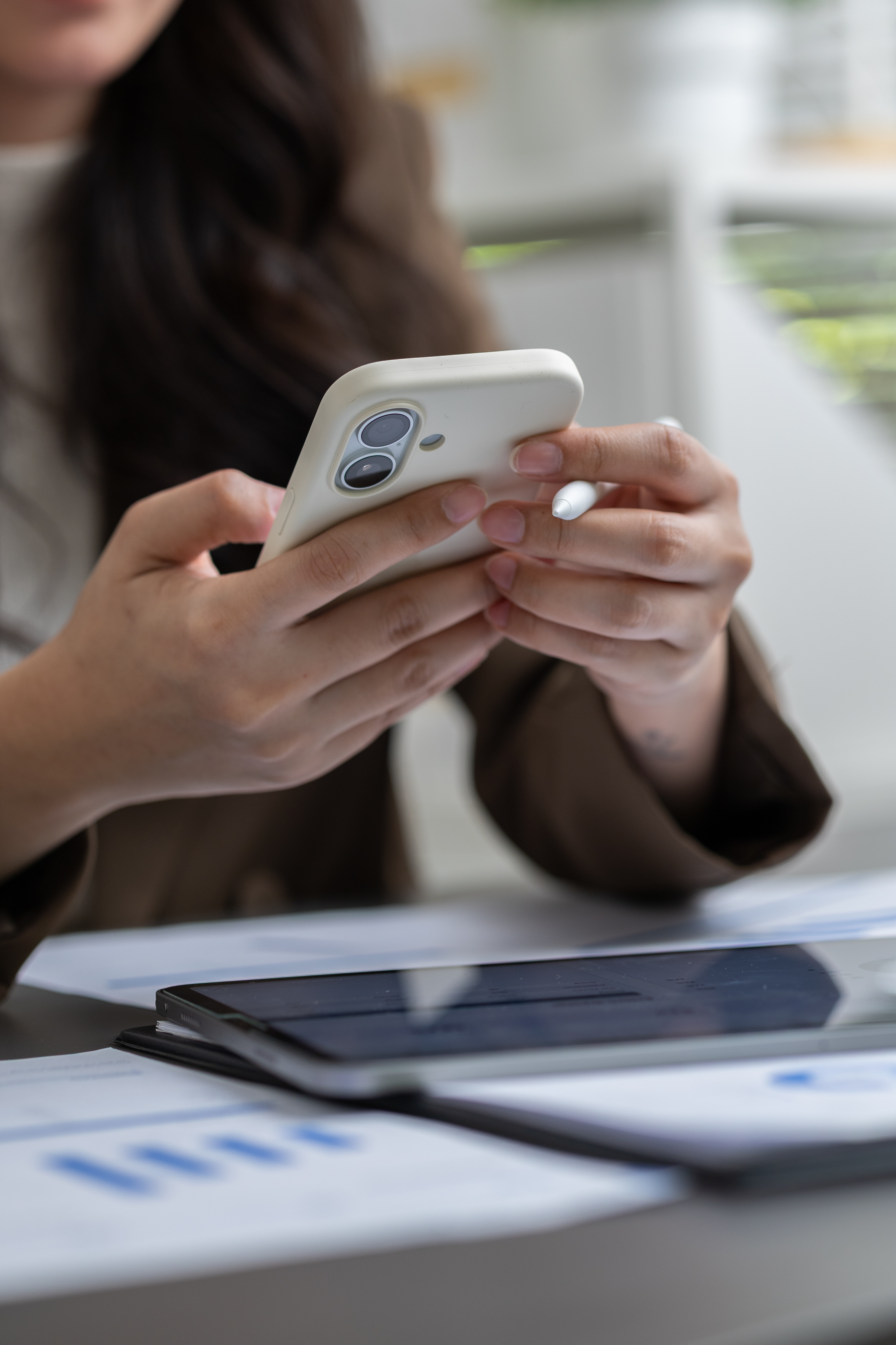 Legal Consultation and Document Review Client reviewing legal documents on a smartphone and tablet at an office desk during a family law consultation